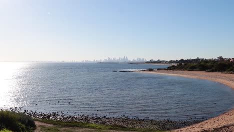 calm beach with city skyline in background