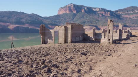 old buildings emerging from empty swamp due to the problems of extreme dryness and lack of rain