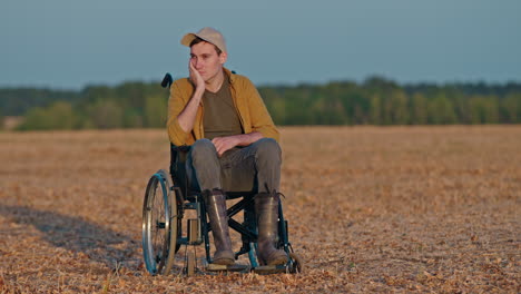 disabled man in a wheelchair in a field at sunset