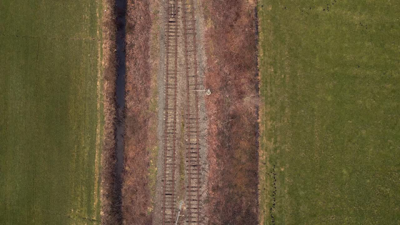 Binari ferroviari abbandonati in un campo rurale
