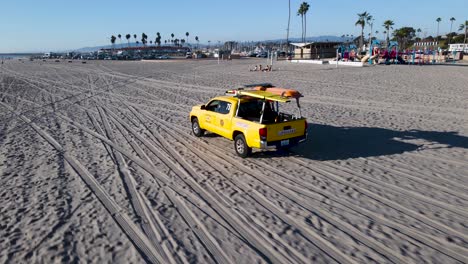 closeup of oceanside lifeguards driving down the beach at oceanside harbor