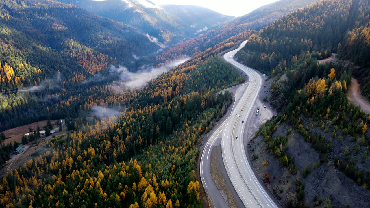 Aerial View of Winding Highway Through Autumn Mountains
