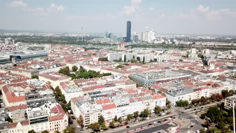aerial flyover amusement park and neighborhood of vienna city at sunny day. downtown with skyline in background. drone forward wide shot.