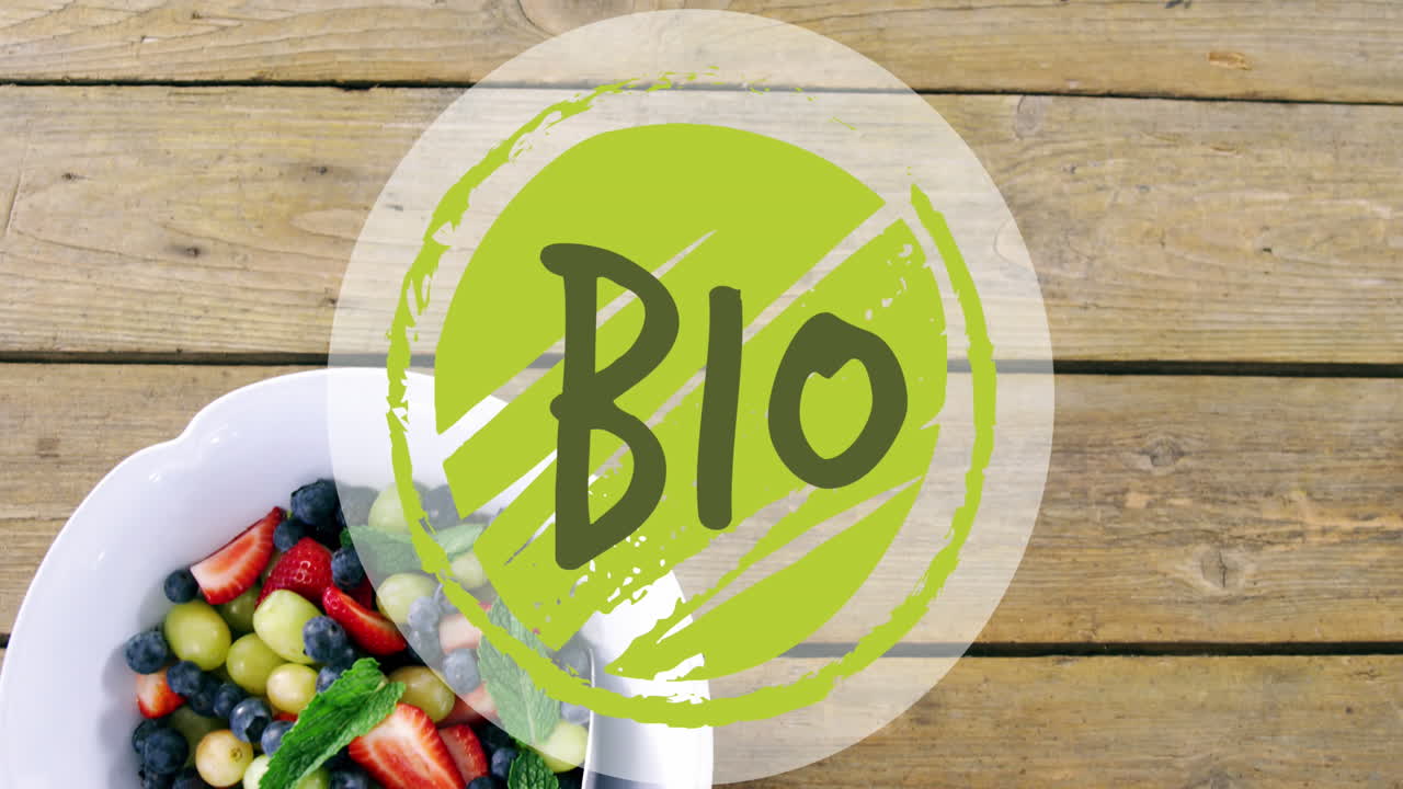animación de un banner de texto biológico contra un plato de ensalada de frutas en una mesa de madera