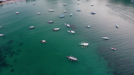 Bay-along-coast-of-Philippines-with-double-outrigger-boats-anchored-in-blue-ocean