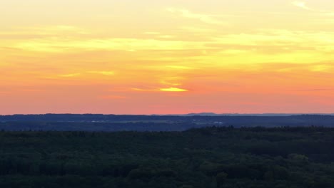 aerial panning footage of moody skyline of colours and dark landscape