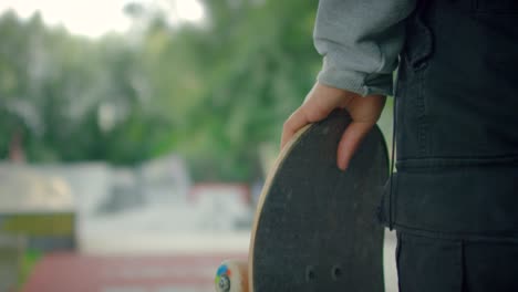 skater sosteniendo tablero en skatepark