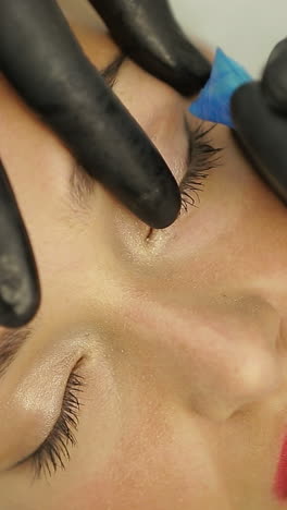 beautician making artificial lashes. cosmetologist making eyeliner permanent make up