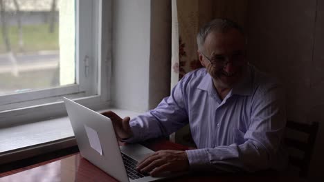 un anciano utiliza una llamada de video en su teléfono inteligente para comunicarse, comunicarse de manera segura con la gente a través de una llamada de vídeo