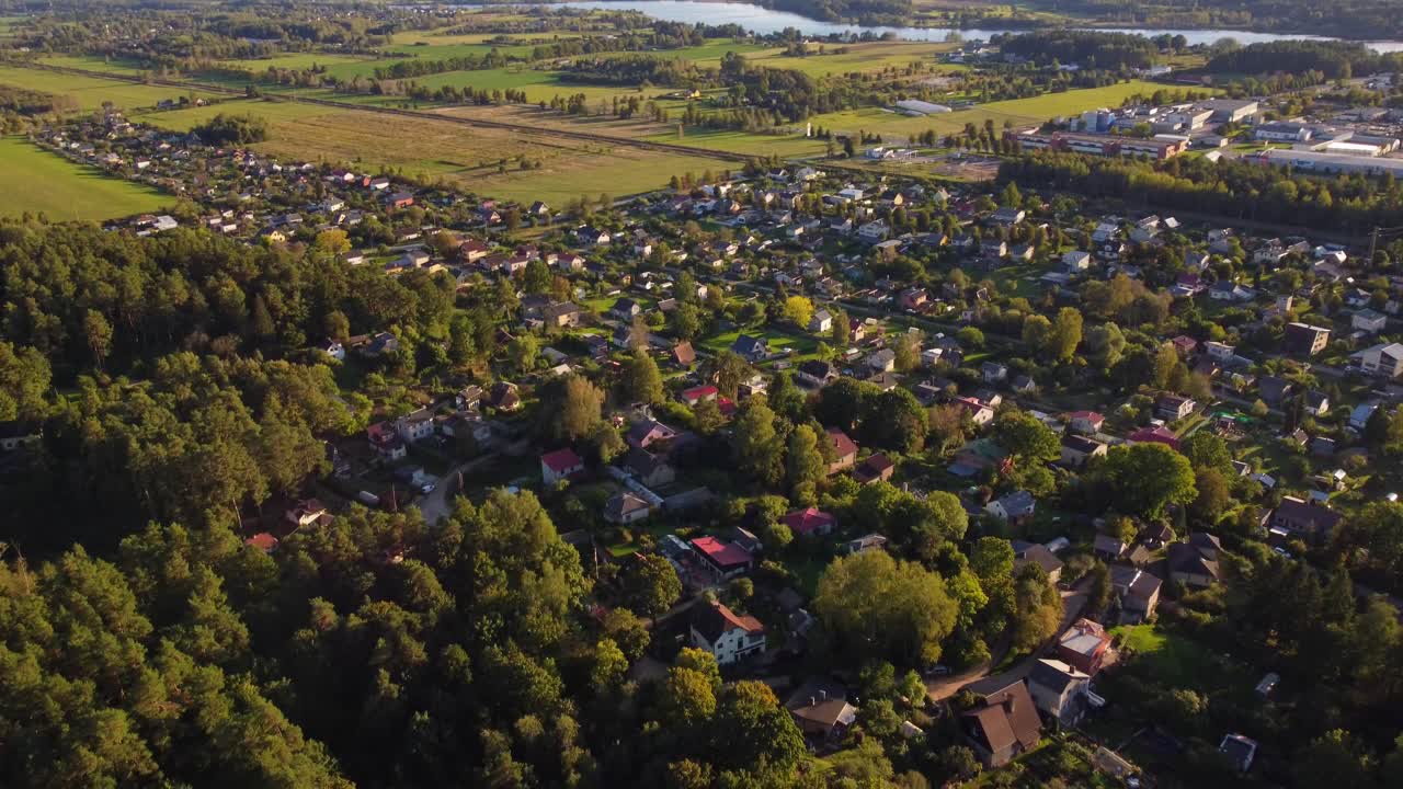 Pulling away aerial view of suburban homes and forest in Ogre, Latvia