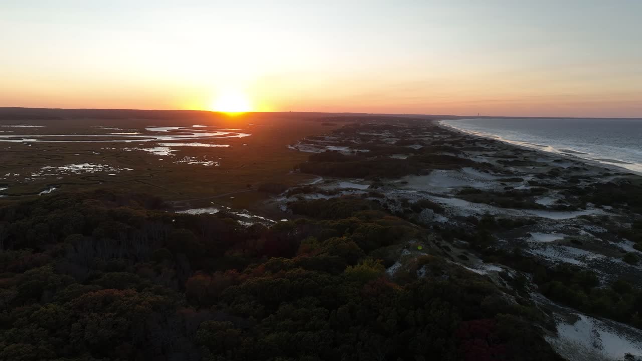 Static aerial view of sunset at Salt Marsh and sand dunes at Cape Cod, Barnstable Massachusetts. Sunset at horizon.