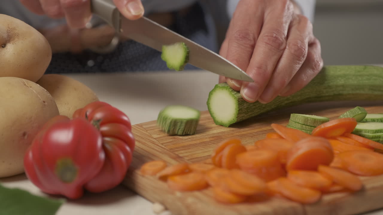 mujer preparando comida mediterránea cortando verduras de calabacín