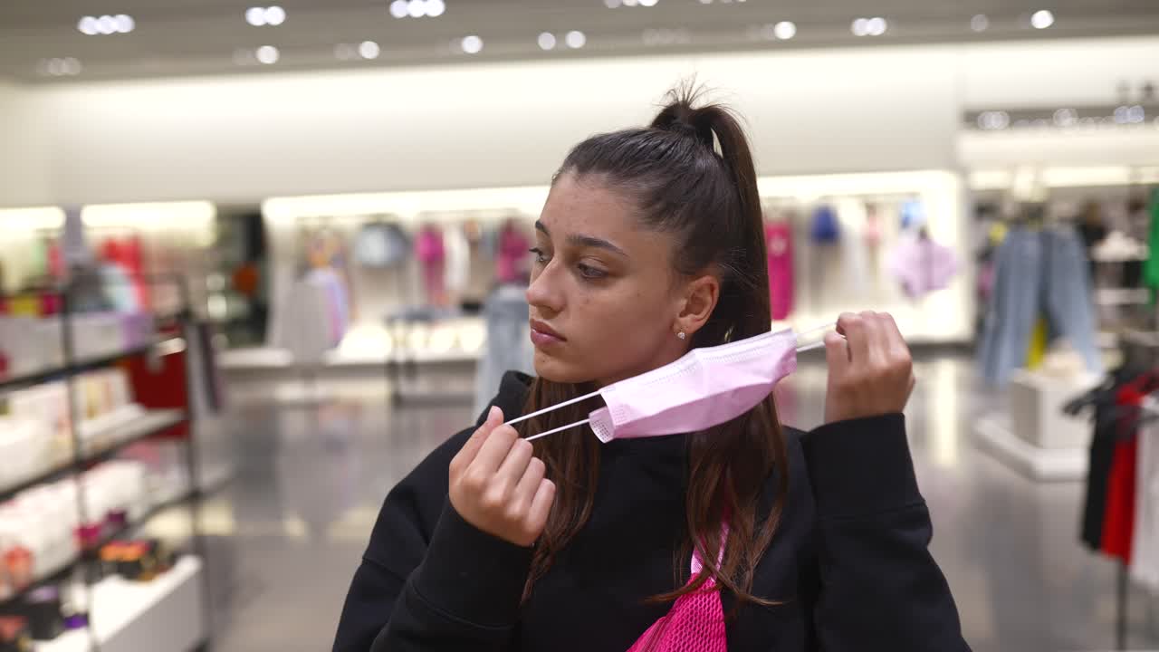 옷 가게 에서 얼굴 마스크 를 조정 하는 젊은 여자