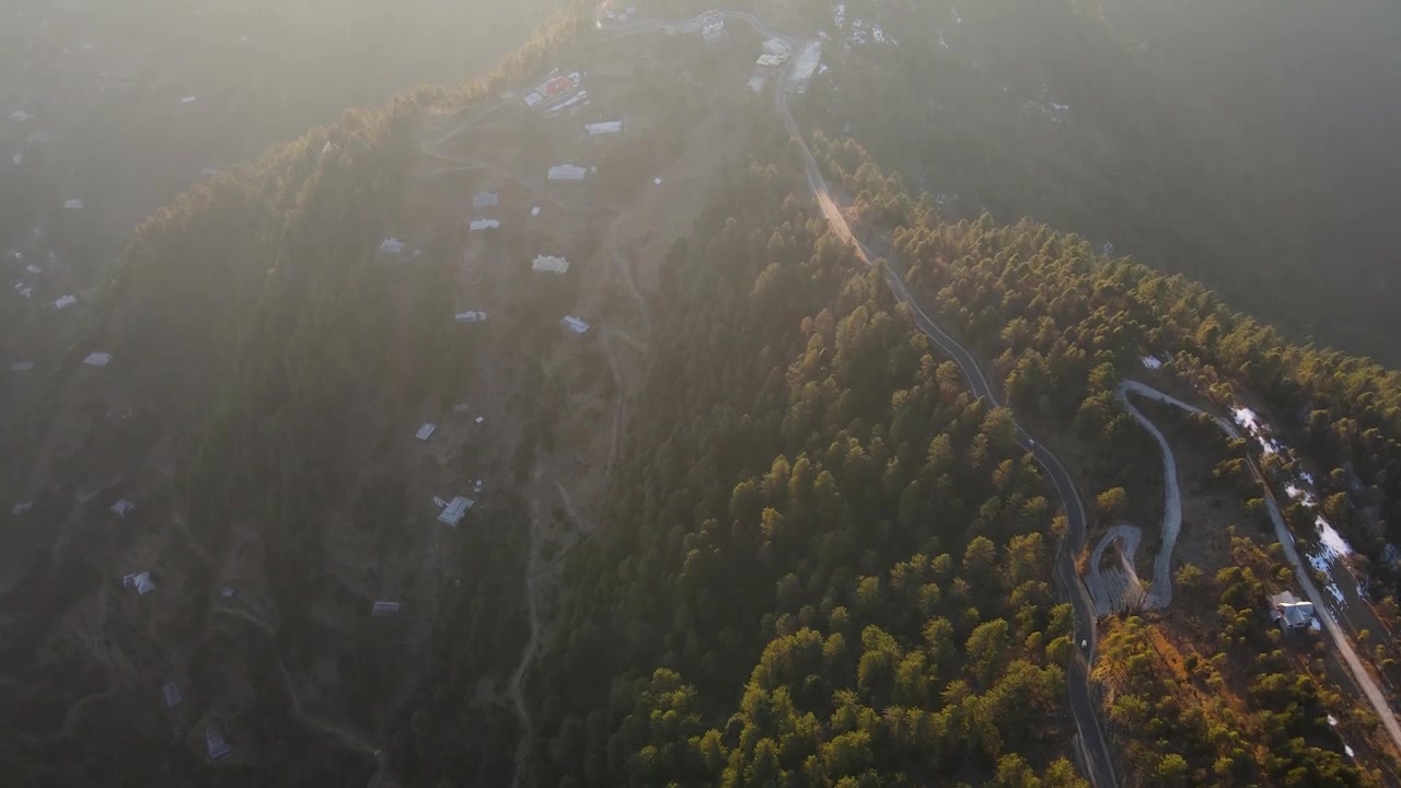 パキスタン、カシミール地方のラワラコット。明るい日差しの下、緑豊かな山々、道路、そして点在する建物が美しい景観を作り出す空撮。