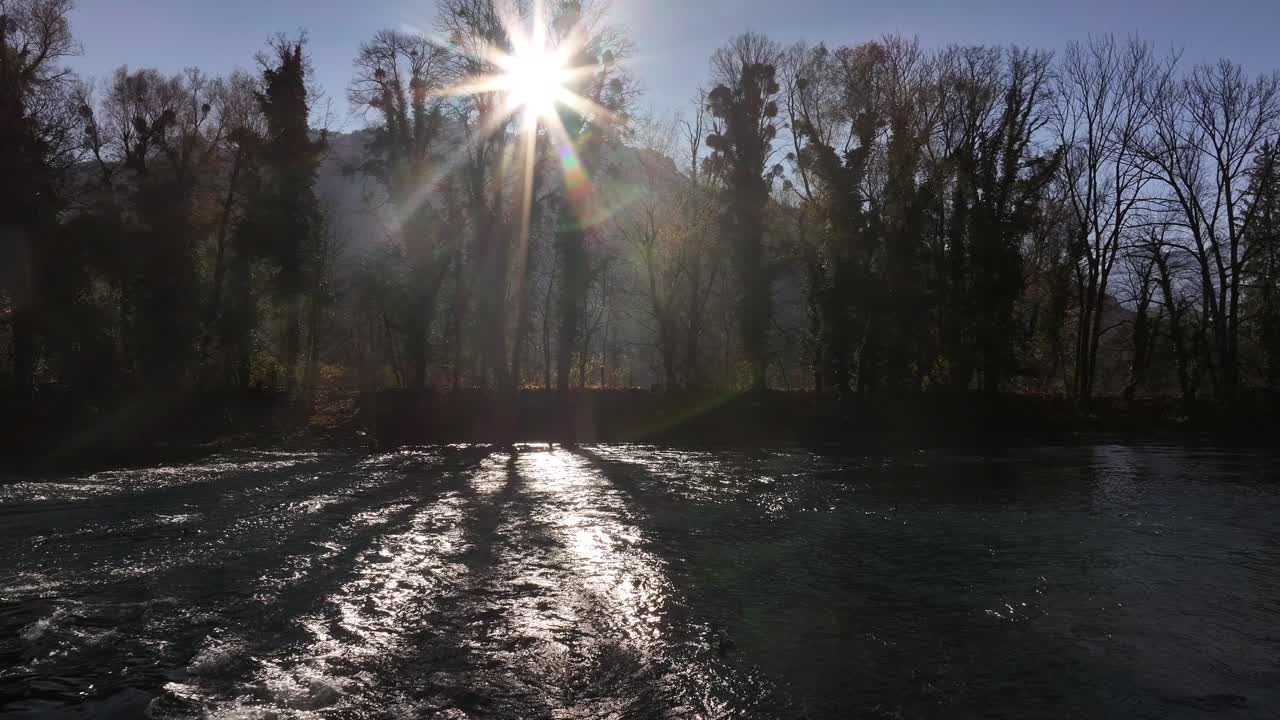 escena de un río con rayos de sol