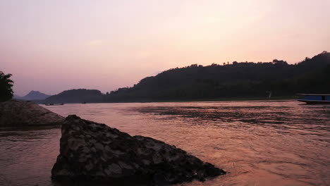 puesta de sol sobre un río con montañas
