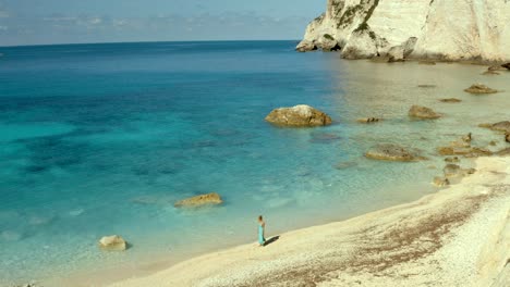 Mujer-Caminando-En-Soledad-En-La-Apartada-Playa-De-La-Bahía-De-Erimitis-En-Paxos,-Grecia