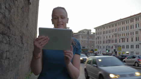 young woman with pad having video chat outdoor