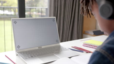 African-american-boy-using-laptop-with-copy-space-on-screen-for-online-lesson-at-home,-slow-motion