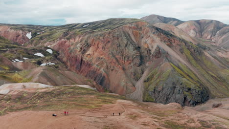 Aerial-view-of-hikers-hiking-colorful-mountains,-Landmannalaugar,-Iceland