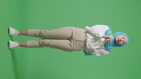 cuerpo lleno de mujer musulmana asiática orando por algo mientras estaba de pie en la pantalla verde estudio de fondo