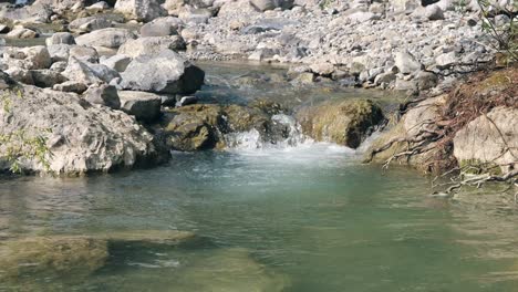 Imagen-Estática-De-Un-Río-Con-Agua-Clara-Y-Fluida-Y-Piedras.