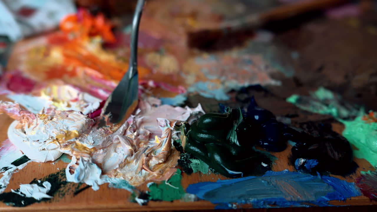 Close up of a woman picking up paint from a palette