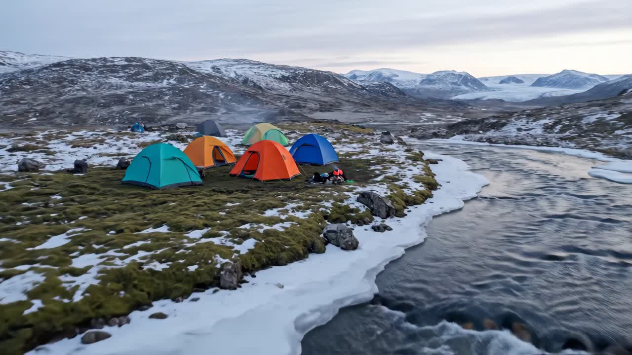 Colorful Tents Pitched by a Frozen River in a Snowy Mountain Landscape