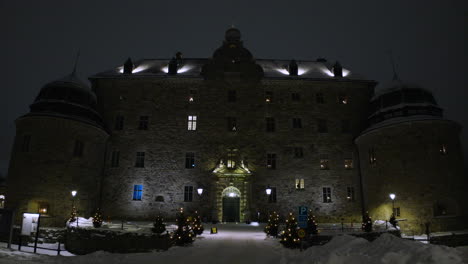 drone push in of entrance to örebro castle in winter at night