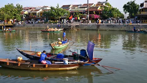 boatmen and boat ladies prepare to take tourists and visitors on a tour of thu bon river at a section of the old quarter in the city of hoi an, vietnam.