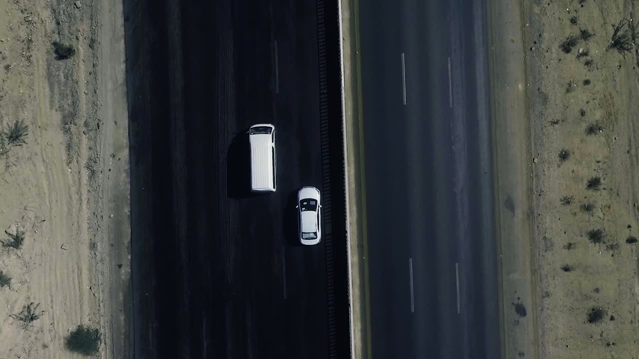 una vista superior aérea en cámara lenta del tráfico que se mueve en una carretera en las áreas del norte