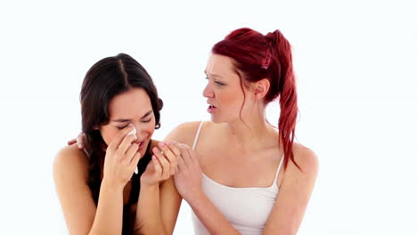 young crying woman being consoled by her friend