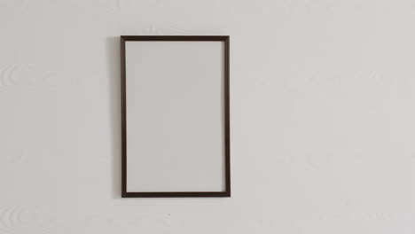 marco negro con espacio de copia en fondo blanco contra una pared blanca