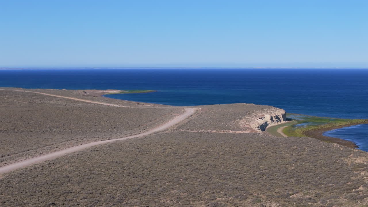 Aerial landscape of Patagonian wild route, coastline road in Puerto Madryn, Argentina, car driving at isolated sandy beach