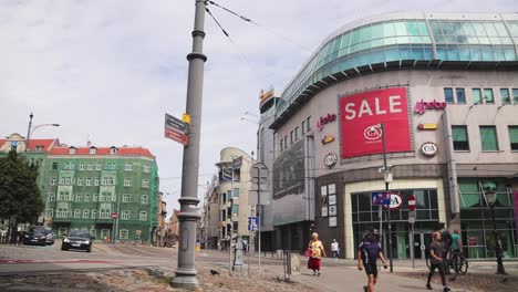 panning shot of kupiec poznanski shopping mall and people walking on the street