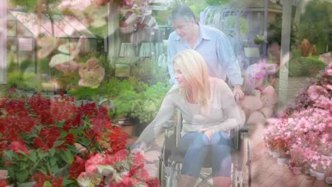 animation of flowers over disabled cuacasian woman sitting in wheelchair