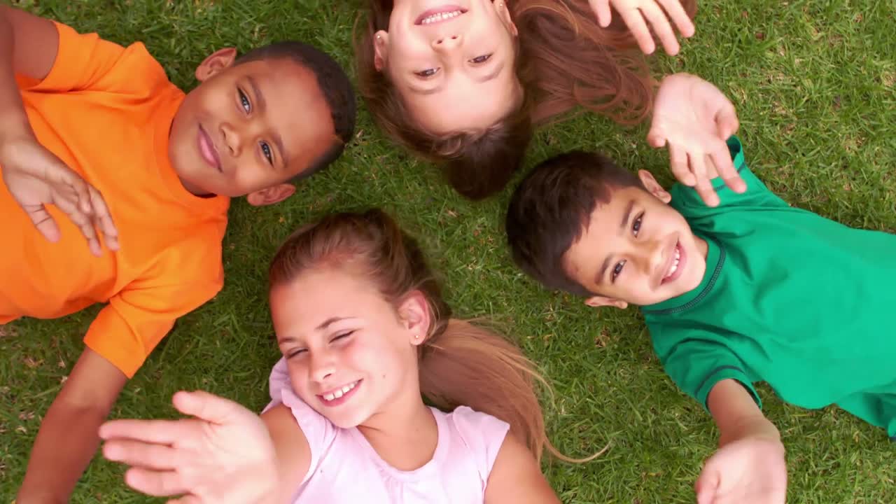 Niños sonrientes tumbados en círculo