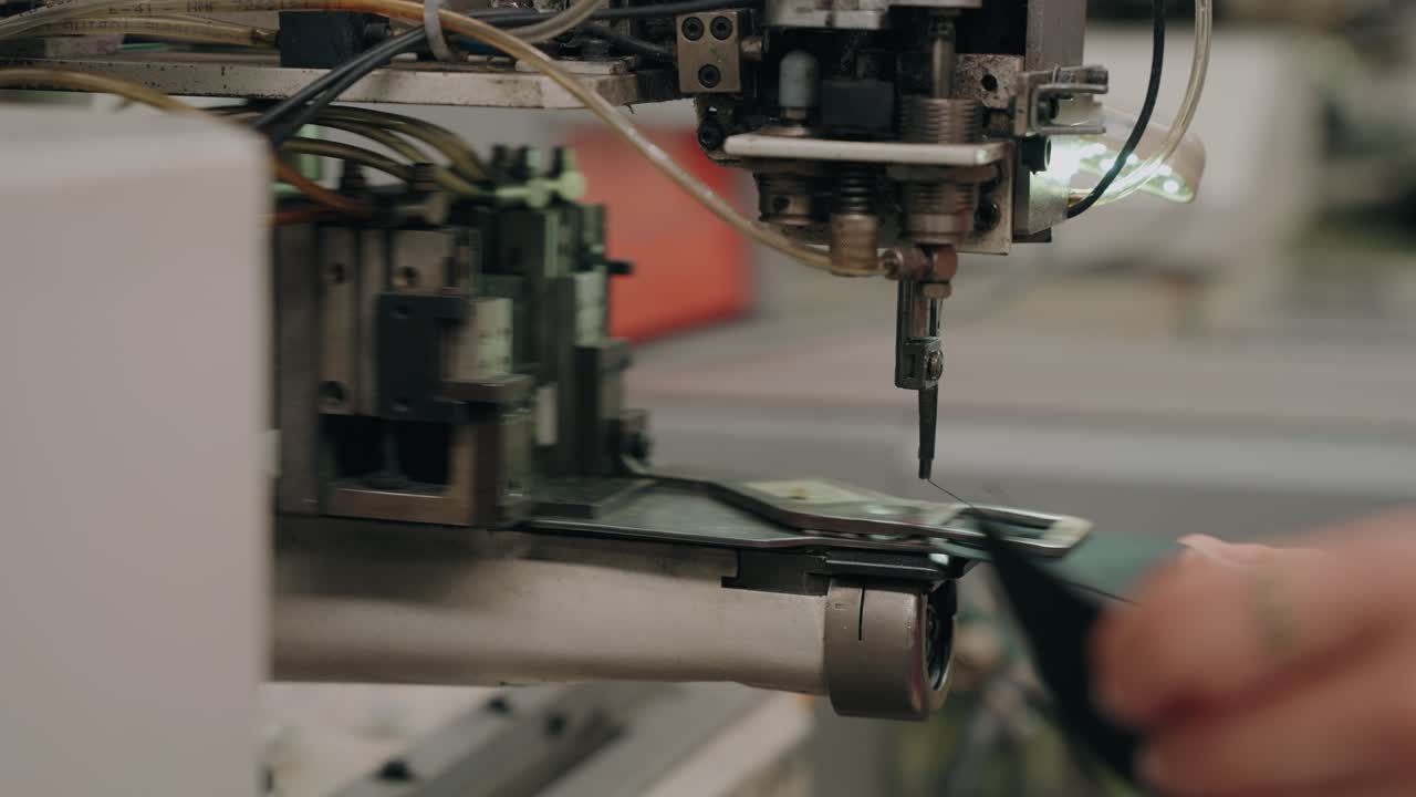 hands guide leather as machine sews shoe components with care and accuracy