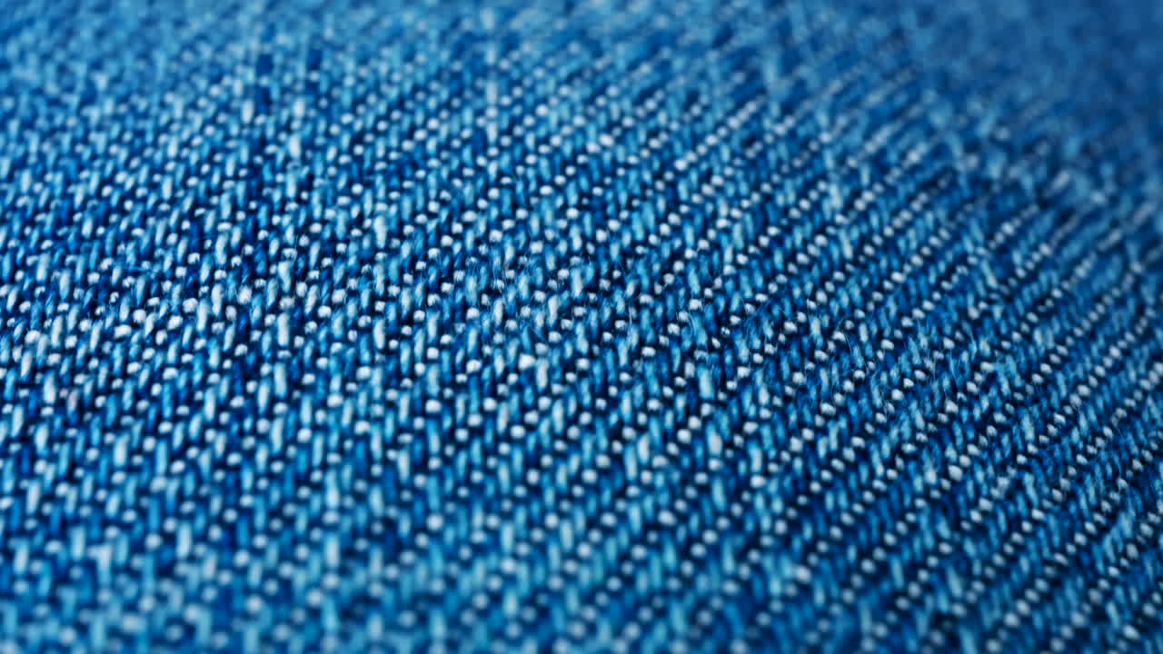 Close up of blue denim fabric texture showing fine threads and detailed textile pattern