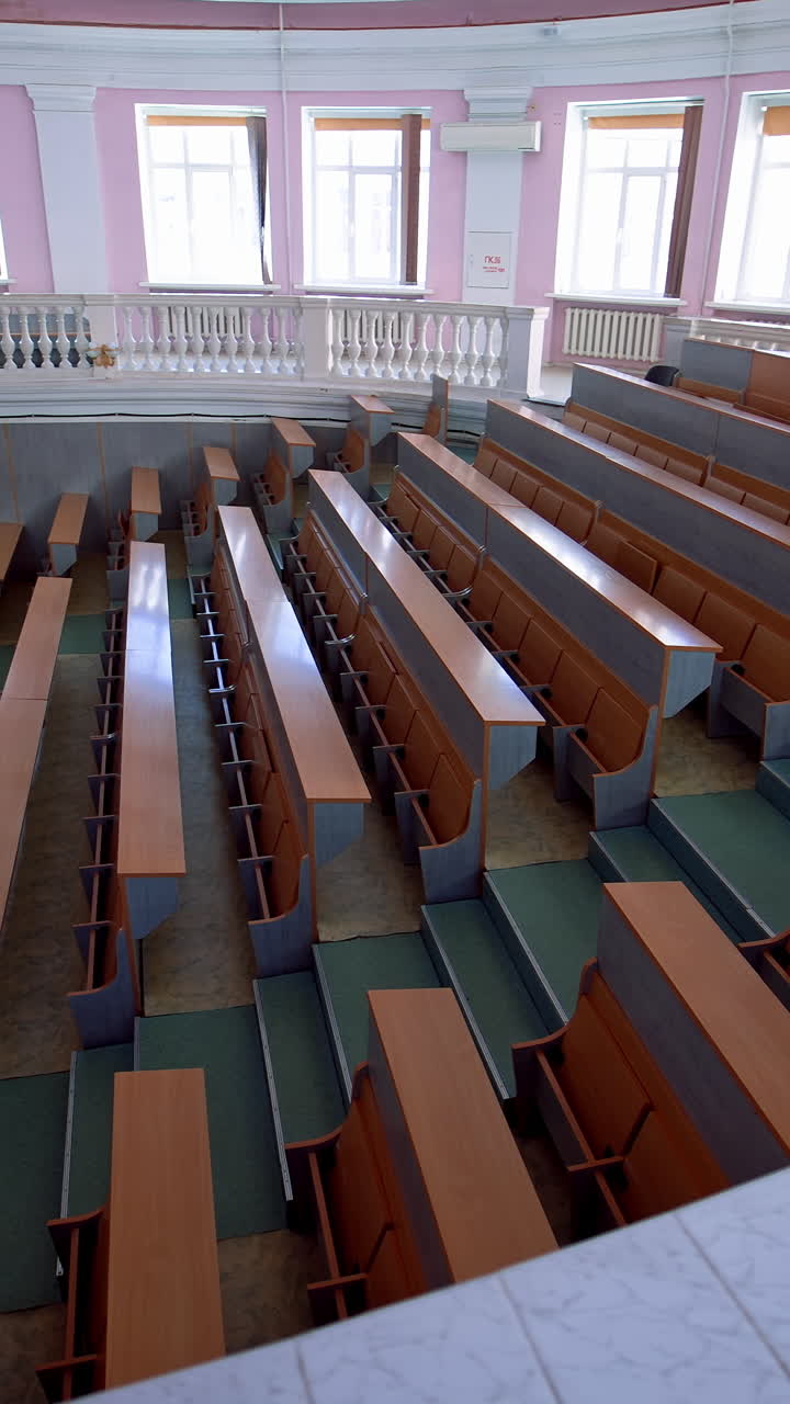 Lecture hall in the university. Panoramic view of educational center indoors. Large auditorium with empty desks during pandemic. Vertical video