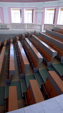 lecture hall in the university. panoramic view of educational center indoors. large auditorium with empty desks during pandemic. vertical video
