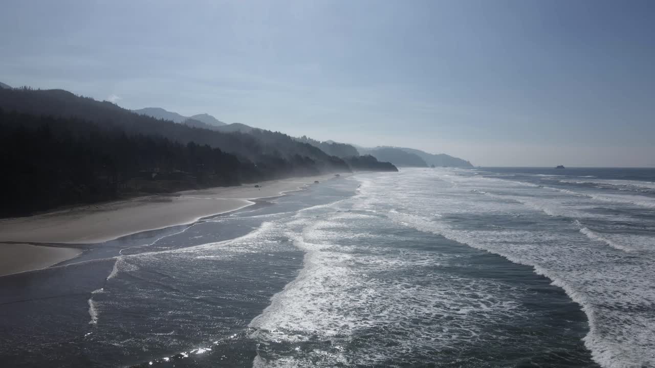 Intense sunshine reflecting off a pristine beach along the Oregon coast, aerial dolly