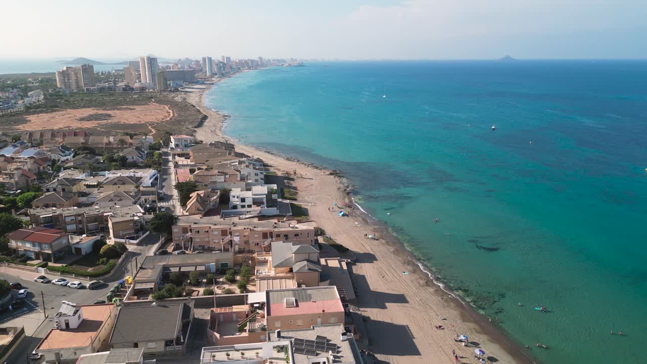 Reverse Dolly aerial view of Playa de Las Sirenas Viejas during a summer day - A spanish beach with a crystal blue water in the municipality of Cartagena, the region of Murcia. Spain