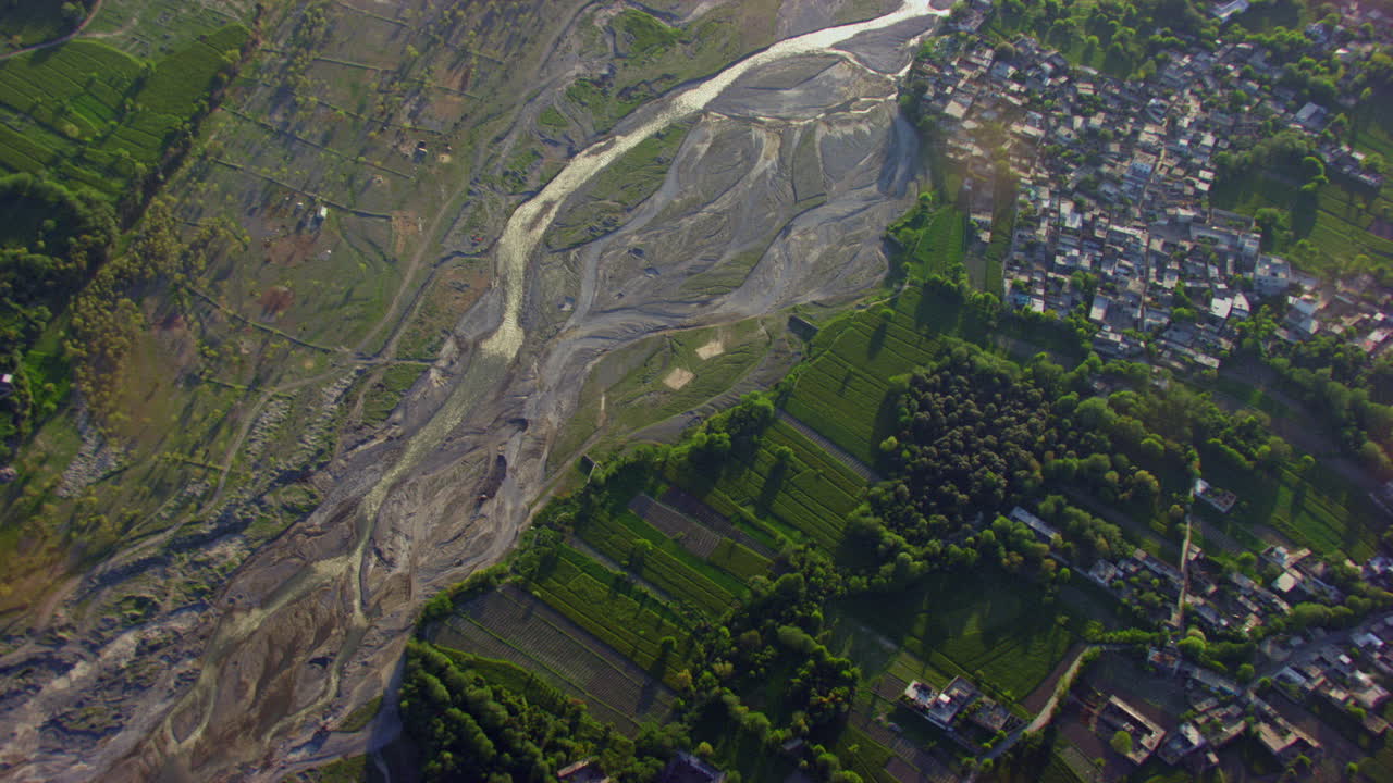 vista aérea de un río y un valle, árboles verdes, pasto y bosque con casas, la cámara está arriba en el río, escasez de agua en el río