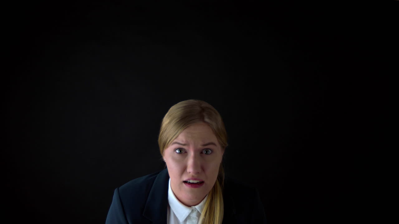 Terrified woman on black background