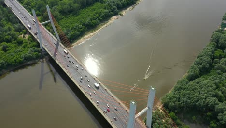 aerial or top view from drone of concrete bridge with asphalt road or highway over big river with city car traffic, urban transportation, toned