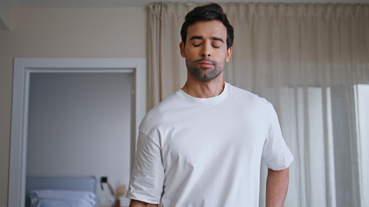 Muscular guy lifting dumbbells in modern apartment closeup. sportsman