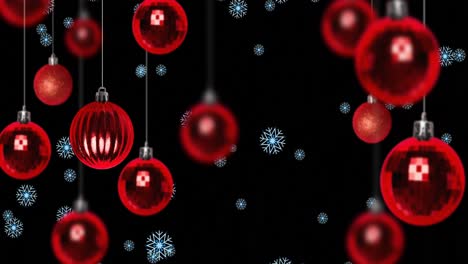 snow falling over red baubles on black background