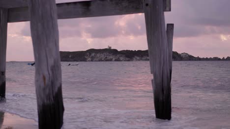 View of Hamelin Island through a wooden archway on the beach, showcasing the natural beauty of the coastline with the ocean in the background.