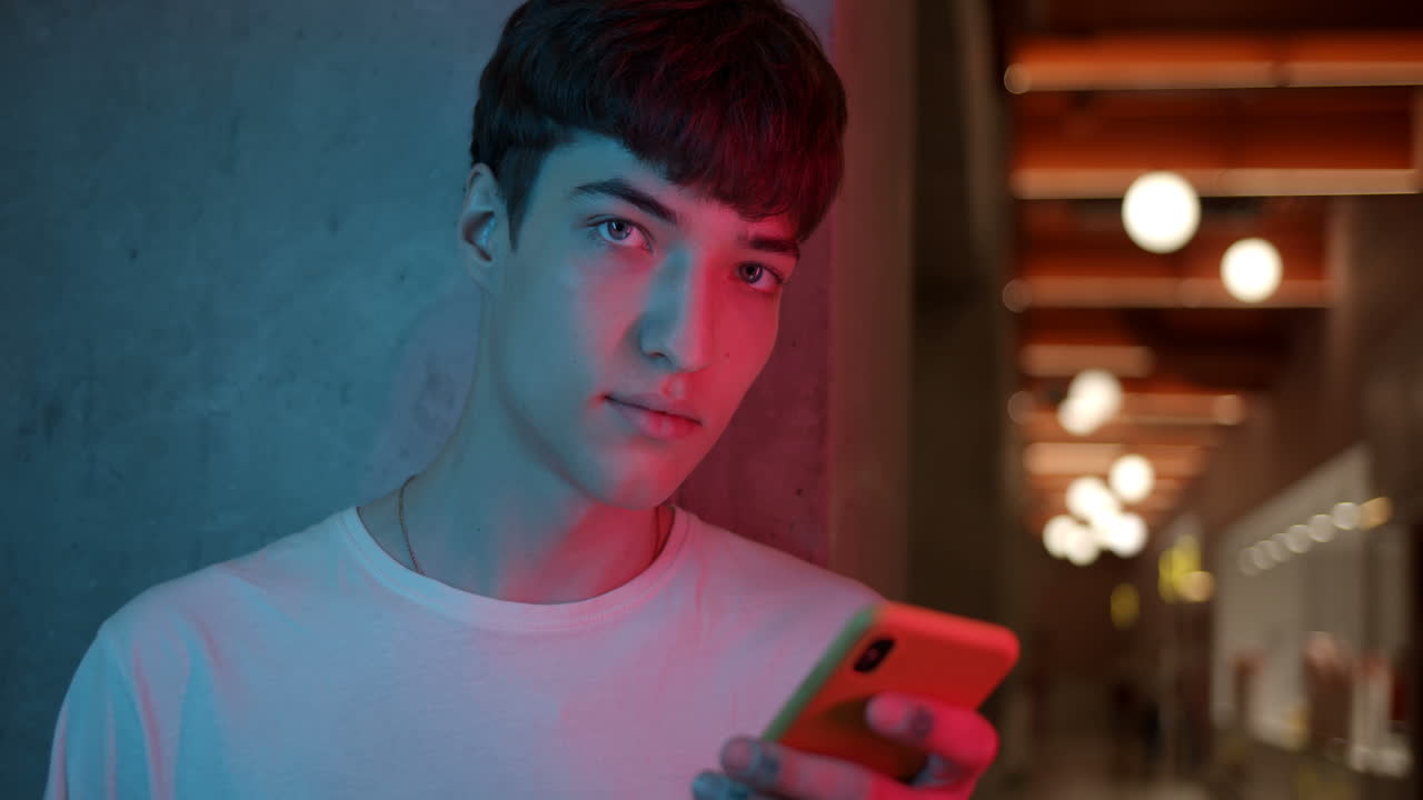 Teenager using smartphone in neon light